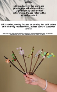 Macro detail of handmade bamboo hair pin with 20cm length and glazed flower ornaments