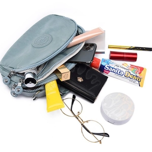 Blue nylon crossbody bag with multiple compartments showing spacious inner storage