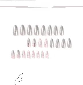 Detail view of pink and silver press-on nails with geometric lines and rhinestones