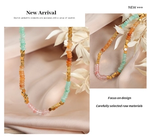 Detail shot of colorful faceted beads and golden cubes on a handmade beaded necklace