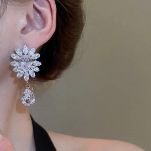 Close-up of model wearing floral water drop zircon earrings in elegant silver finish