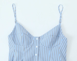 Détail d'un top en popeline à rayures bleues et blanches avec boutons et fines bretelles