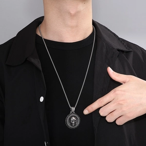 Silver skull pendant necklace shown on a model wearing black shirt for punk style look