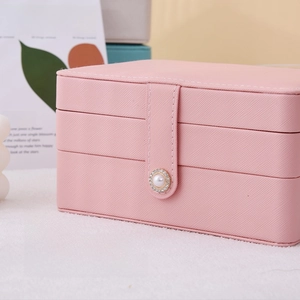 Detail of pink PU leather jewelry box featuring a luxury pearl and rhinestone snap closure