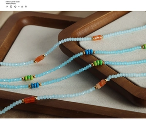 Détail du collier de perles de turquoise fait main avec des billes dorées sur plateau