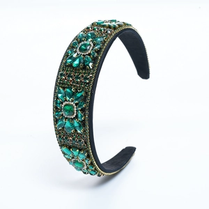 Vintage Baroque velvet headband with green crystals and gold rhinestones on white backdrop