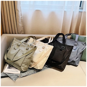 Waterproof nylon tote bags shown in light green, beige, black, and blue with dual straps