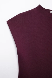 Detail of burgundy knit dress showing round neckline and ribbed fabric texture