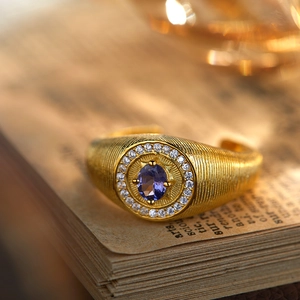 Vintage gold S925 silver ring with oval tanzanite gemstone on a vintage book background