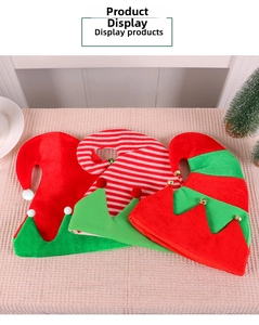 Detailed view of plush red and green Christmas elf hats with bells on checkered background