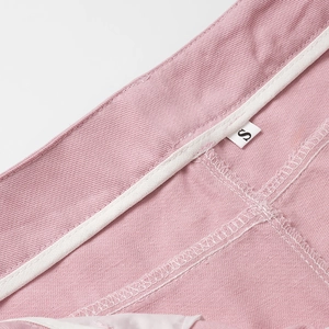 Vue macro de la taille du jean rose avec liseré blanc et étiquette de taille S