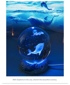 Detailed macro view of 3D dolphin inner carving crystal ball with blue LED moon base