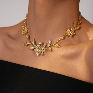 Close-up of golden leaf and flower necklace with sparkling rhinestones on model
