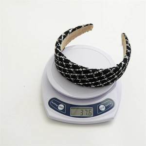 Classic black and white tweed headband weighing 37.6g on a digital scale