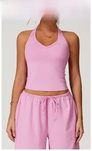 Model wearing a rose pink yoga set with a halter top and drawstring shorts for fitness