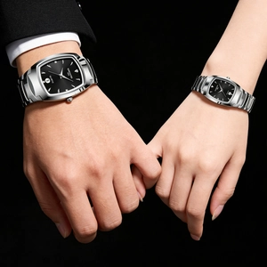 Close-up of couple's wristwatches with rectangular black dials and steel bands