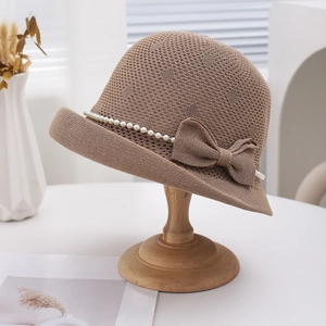 Chapeau de soleil tricoté beige avec perles et nœud sur support en bois élégant