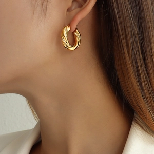 Chunky twisted gold hoop earrings in 18K gold plated stainless steel on model