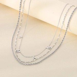 Close-up of silver layered necklace with MAMA letter pendants and twisted rope chain