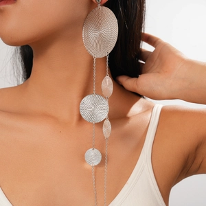 Close-up of layered silver geometric circular drop earrings on a professional model