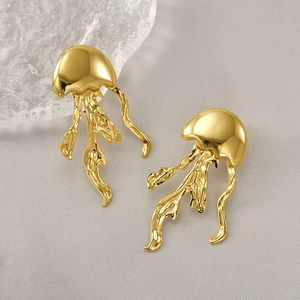 Polished golden jellyfish earrings with streamlined tentacles on a minimalist backdrop