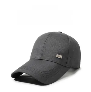 Close-up of dark grey twill baseball cap fabric with small square metal logo detail