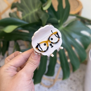 Pink acetate hair claw clip featuring a cartoon puppy with tortoiseshell glasses detail