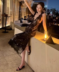 Détail d'une robe longue à paillettes noires avec col en V profond sur un mannequin