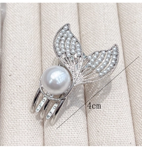 Detail of 4cm silver fishtail hair claw clip with inlaid pearls on striped fabric