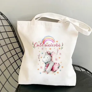 Off-white canvas unicorn tote bag with rainbow print on a modern black chair