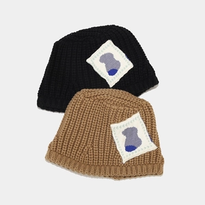 Thick knit bucket hats in black and brown colors with decorative woven patch for women