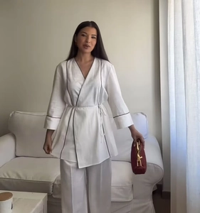 Detail eines weißen Loungewear-Sets mit schwarzer Paspelierung und Gürtel zum Binden