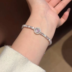 Detailed view of an elegant silver bracelet with pink and clear gemstones worn on a wrist