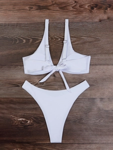 Bikini bianco due pezzi con spalline regolabili e fiocco anteriore su legno scuro