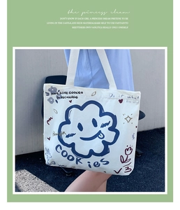 Detail of a large beige canvas tote bag with a cute blue cartoon cloud and COOKIES print