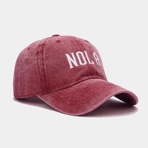 Vintage red washed cotton baseball cap with white NOLA embroidery in a 45-degree view