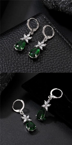 Detailed macro view of emerald green teardrop earring with zircon floral accents
