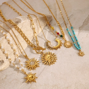 Set of 6 gold star necklaces with pearls and turquoise beads on natural stone background