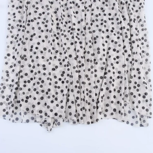 Close-up of lightweight polka dot chiffon fabric with elegant draping and pleated details