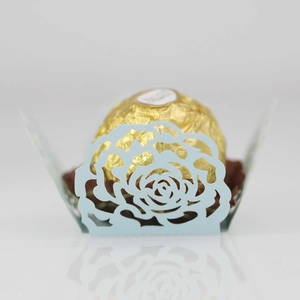 Detail of laser-cut light blue rose hollow paper candy wrapper with mirror reflection