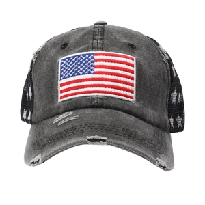Nahaufnahme der USA-Flaggenstickerei auf dunkelgrauer Trucker-Cap im Distressed-Look