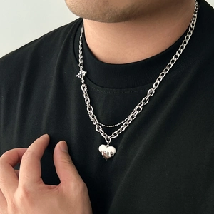 Silver double layer necklace with Cuban chain and melted heart pendant on a model