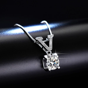 Detailed view of silver V-shaped pendant with pavé diamonds and a round moissanite stone