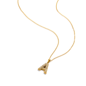 Macro shot of gold initial A pendant necklace with sparkling pavé crystal diamonds