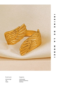 Detail view of gold feather ring with matte texture and adjustable open wing design