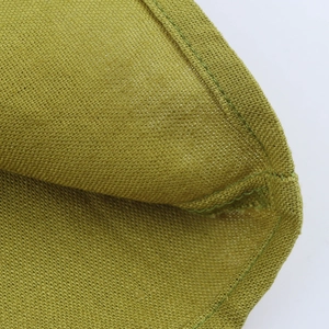 Detailed close-up of olive green linen fabric texture and stitching on the dress