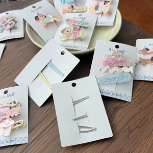 Close-up of cute acrylic hair clips with puppy and bow designs on a ceramic tray
