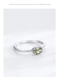 Vue macro d'une bague en argent S925 avec une pierre précieuse ovale vert olive sertie à griffes
