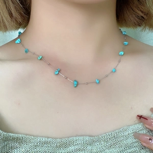 Macro view of light blue irregular natural stones on a fine silver stainless steel chain
