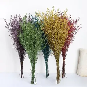Macro detail of five dyed dried Limonium flower bundles in purple, green, blue, yellow, and red